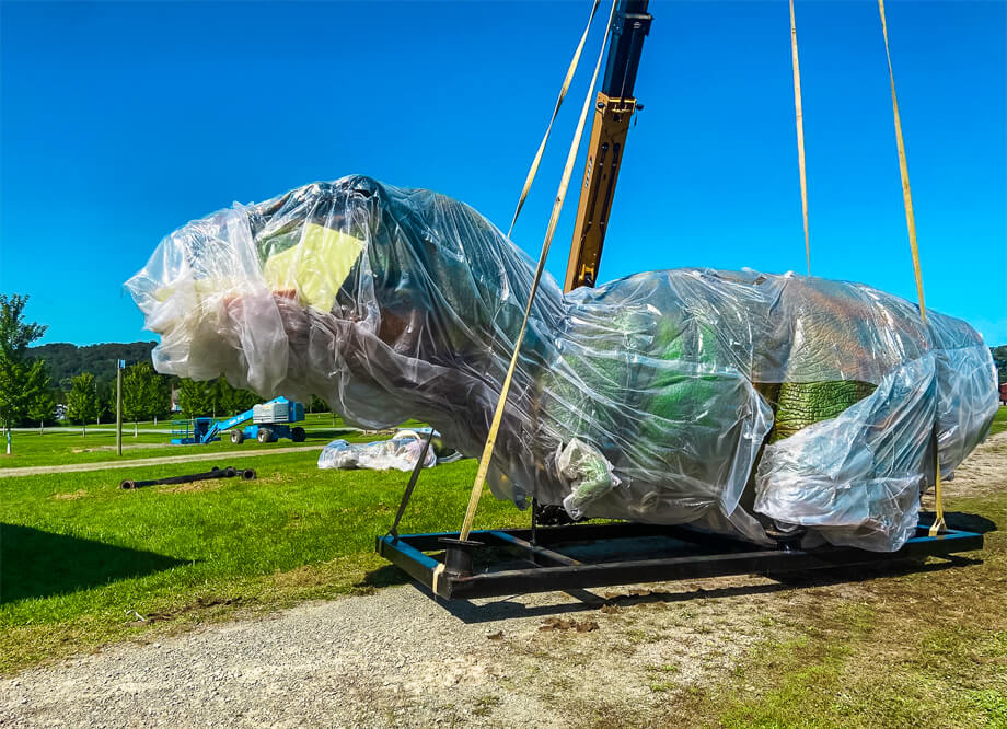 A 6-meter-tall green animatronic Tyrannosaurus Rex is being installed