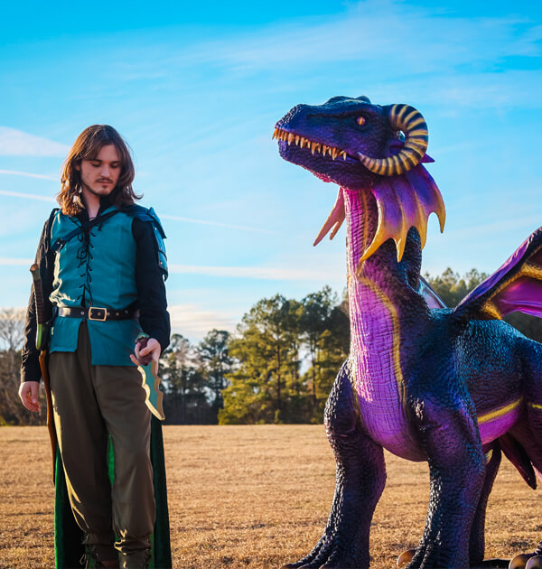 Man in armor and purple robot animatronic flying dragon on the fable fest lawn